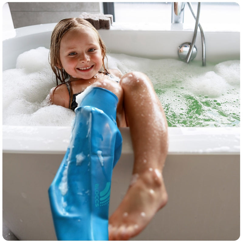 young girls wearing a bloccs short leg cast cover in the bath