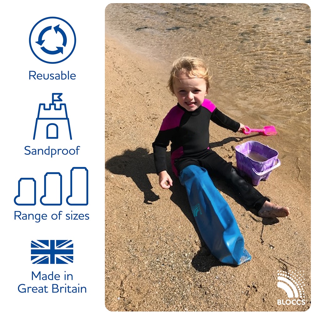 Young boy sitting in the sand at the beach wearing a bloccs full leg waterproof cast protector