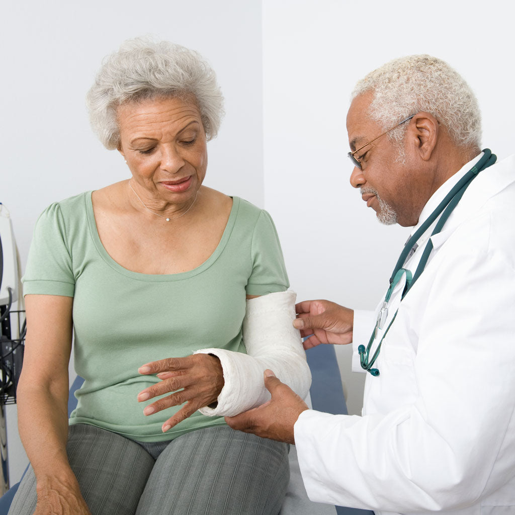 Woman having her arm cast examined by a doctor