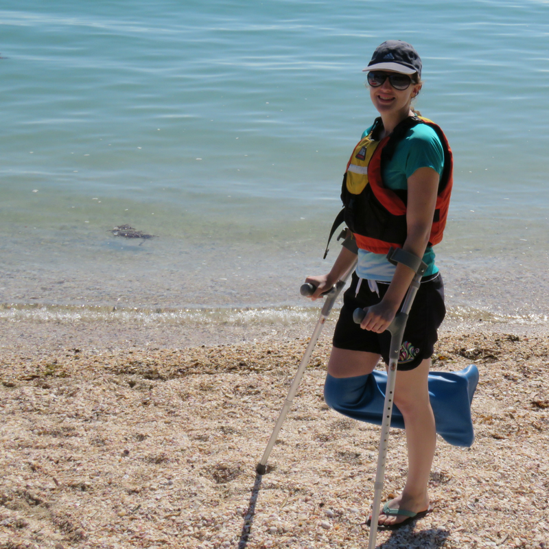 Girl wearing a waterproof cast cover on a beach