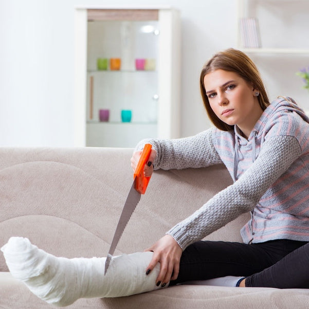 Girl trying to cut off her cast with a saw