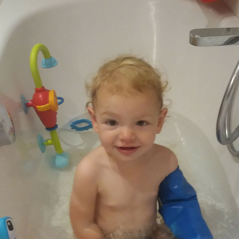 Little Sarah wearing her bloccs full arm cast cover at bathtime